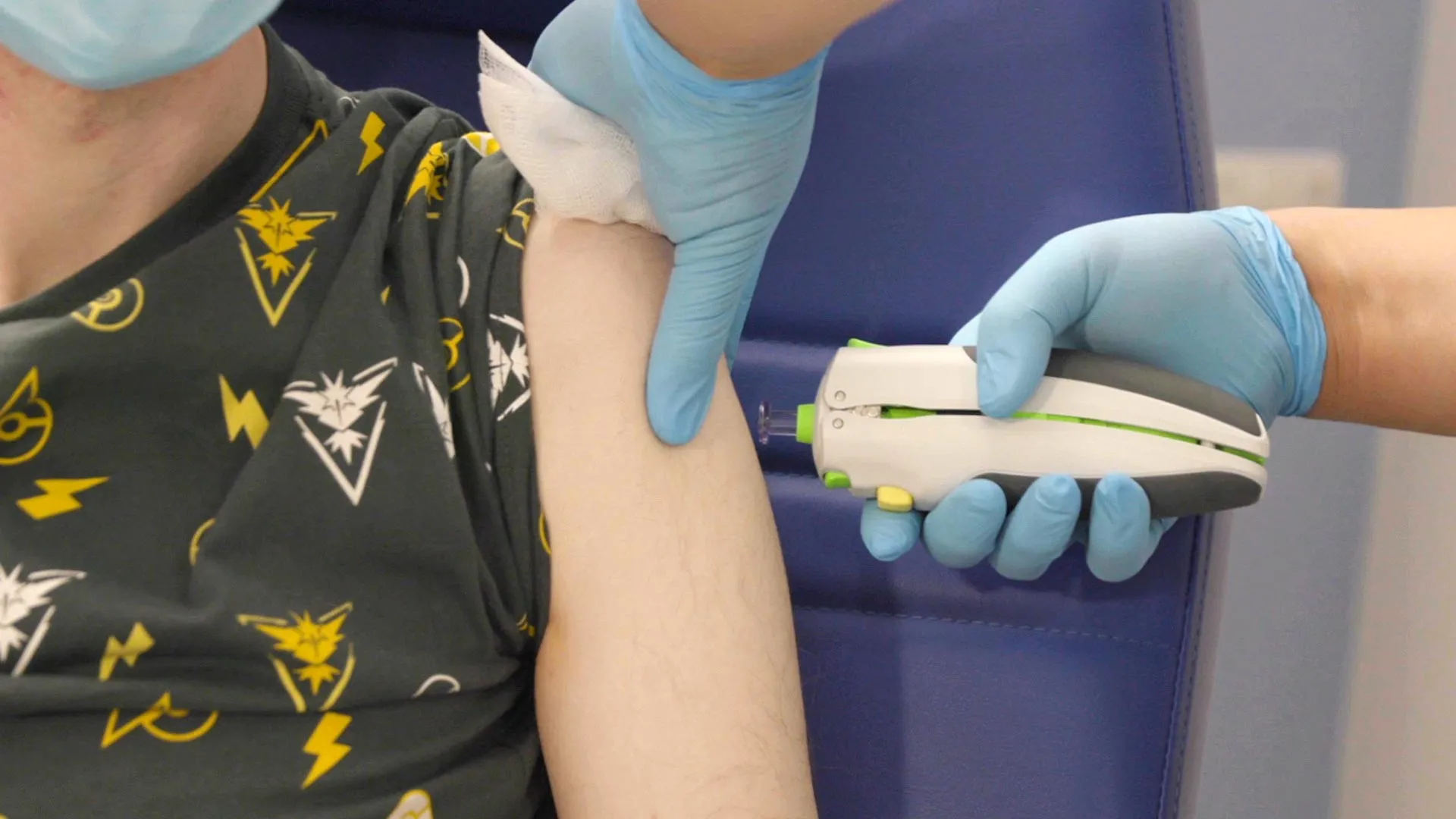 A volunteer receives the pEVAC-PS coronavirus vaccine via a needle-free microfluidic jet to the upper arm.