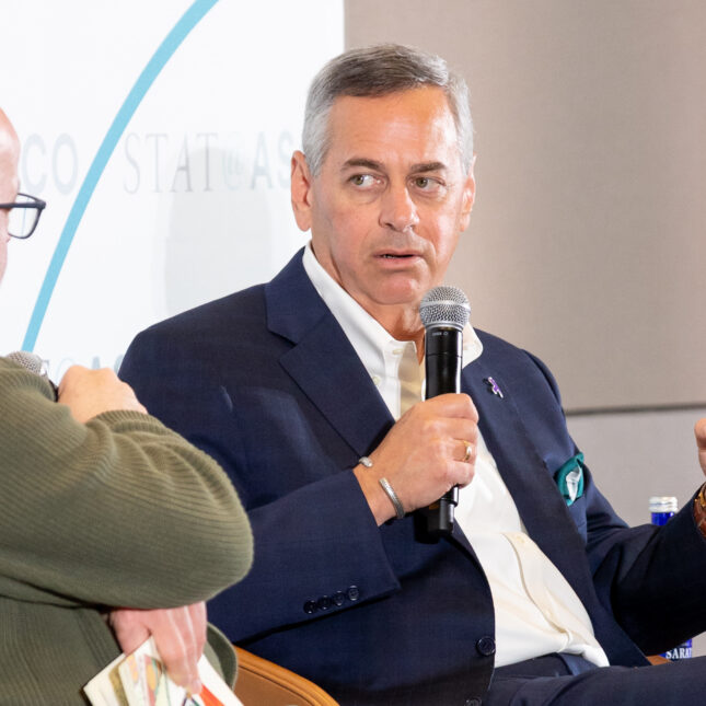 Revolution Medicines CEO Mark Goldsmith speaking into a microphone at a STAT panel at ASCO 2026.