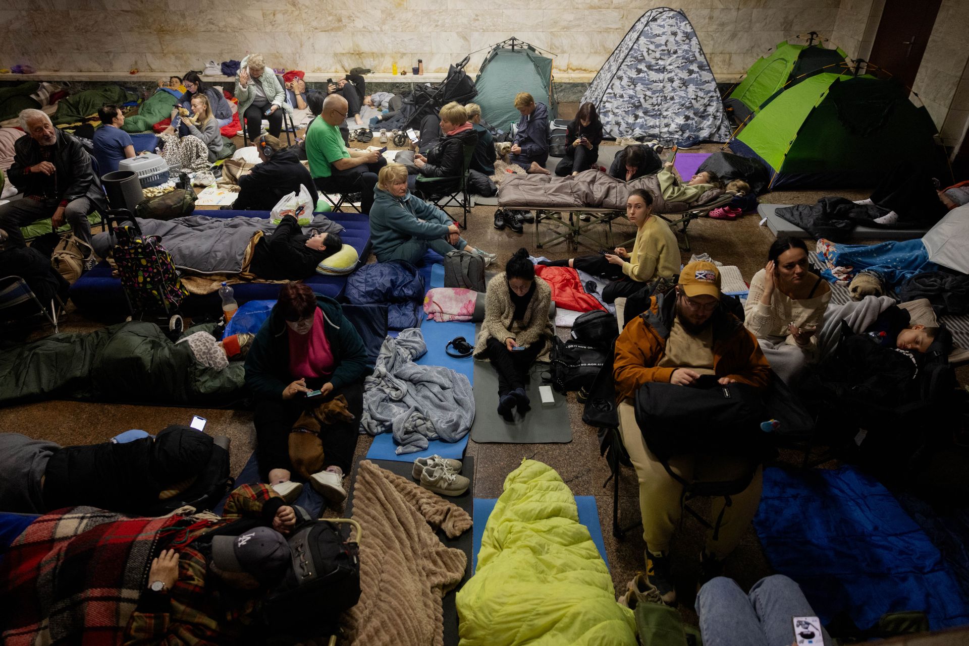 Civilians sheltering with sleeping bags and tents in a Kyiv metro station during the air alarm.